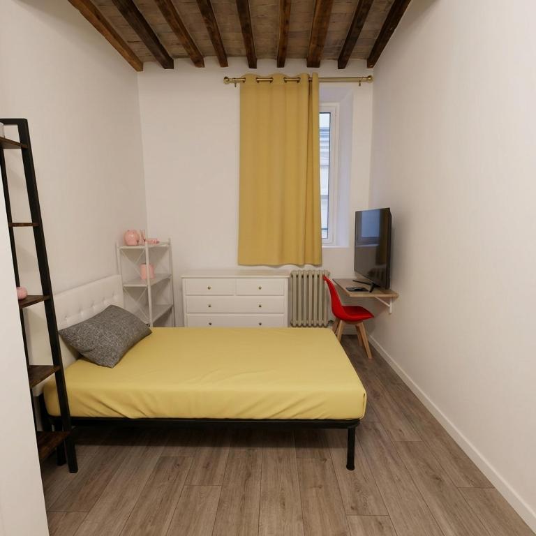 a bedroom with a yellow bed and a desk at B&B Casa Merulo- Camera singola con bagno privato in Parma