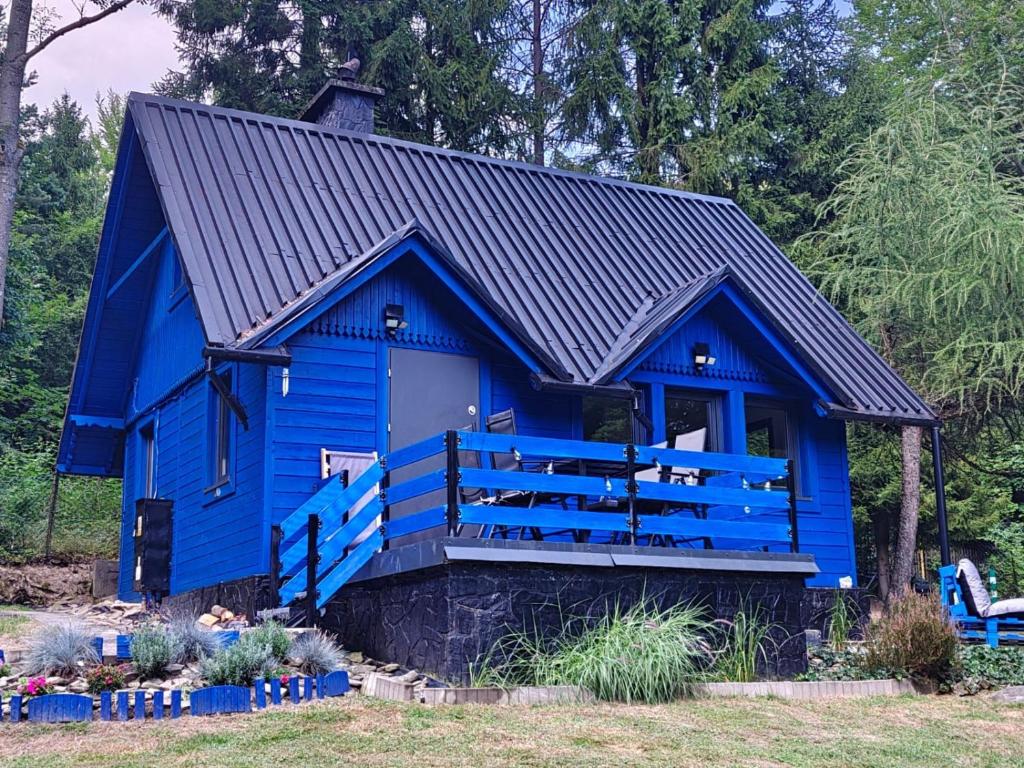 a blue house with a porch and a roof at Modry Domek Szczyrk domek na wyłączność z kominkiem in Szczyrk