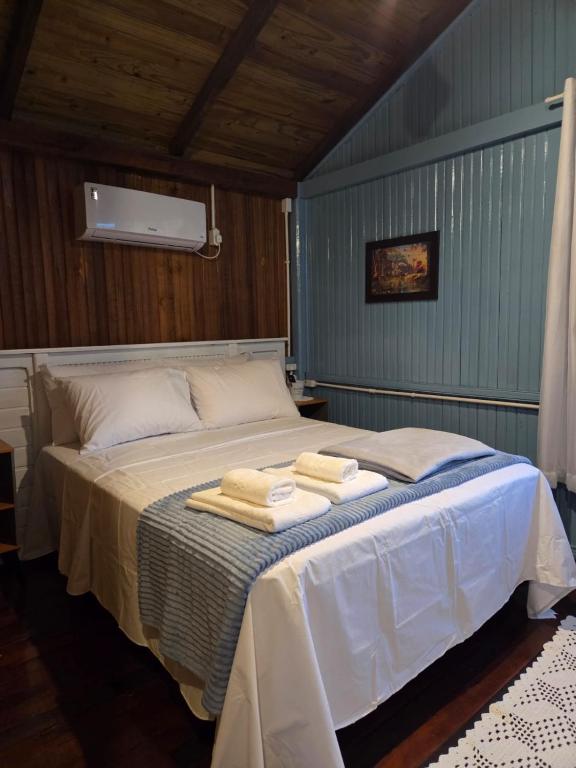 a bedroom with a bed with towels on it at Vila dos Tropeiros in Lauro Müller