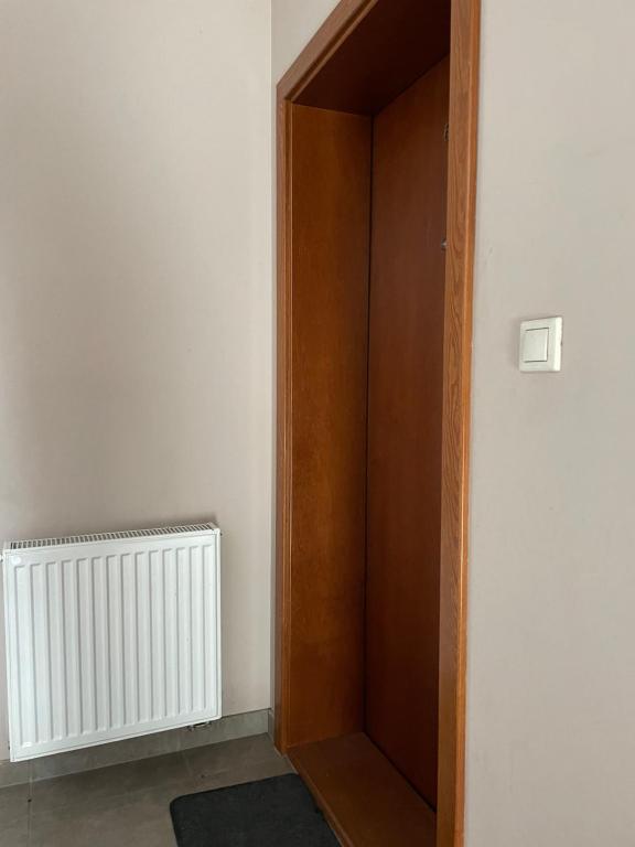 a wooden door in a room with a radiator at Różowa in Miłosław