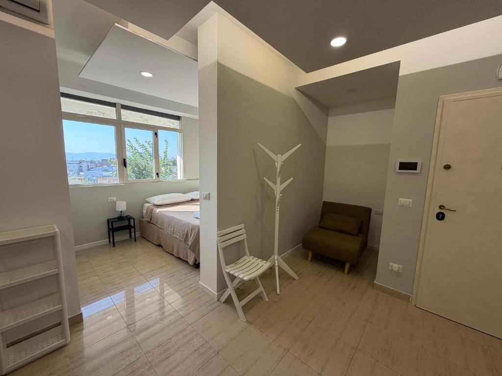 a bedroom with a bed and a chair and a window at MONTREAL FLAT STUDIO in Reggio di Calabria