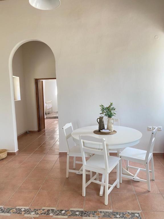 a dining room with a white table and chairs at Matsipeti in Kythira