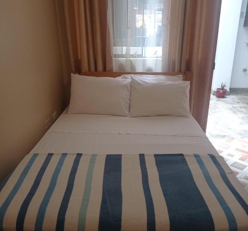 a bedroom with a bed with a blue and white comforter at Hospedaje Josué Paracas in Paracas