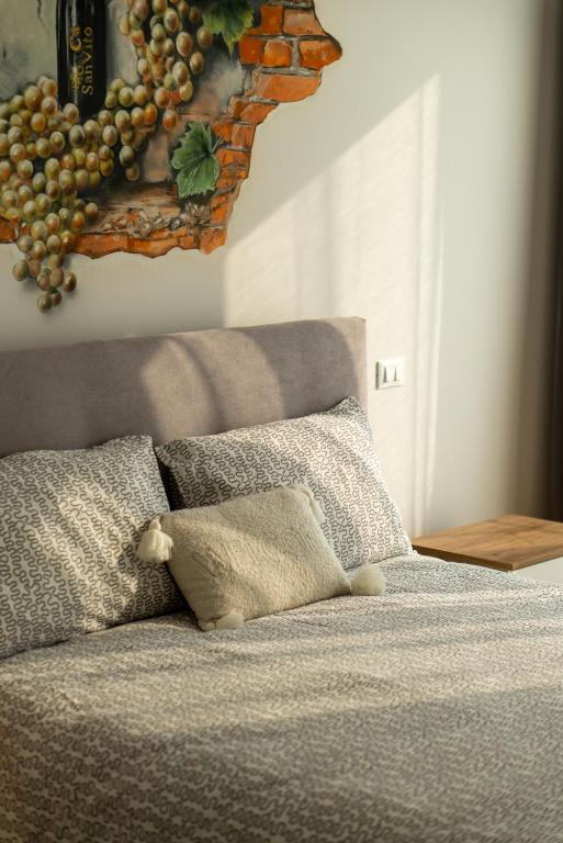 a bed with a picture of grapes on the wall at Casa Delle Bollicine in Bigolino