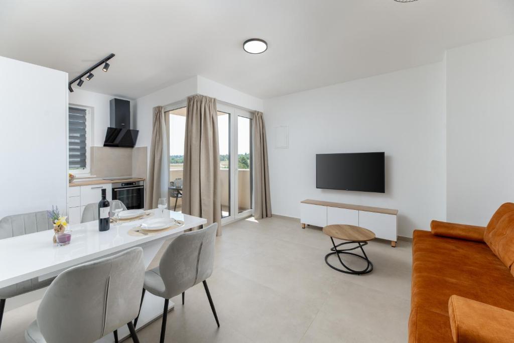 a living room with a white table and chairs at Apartman Tena in Barban