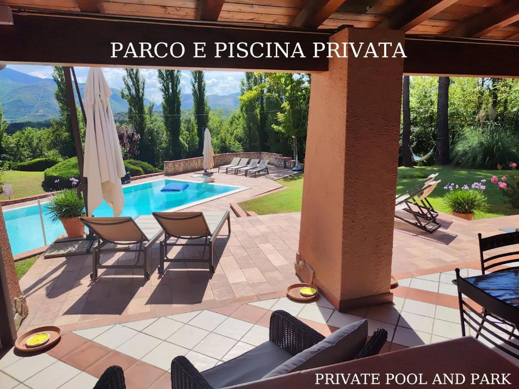 a patio with chairs and a pool and a sign that reads panoco e p at Villa Abete Azzurro con Piscina in Casalvieri