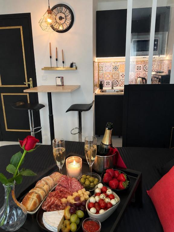 a table with a tray of food and wine glasses at La Suite Nocturne Climatisée avec écran Cinéma in Fère-en-Tardenois