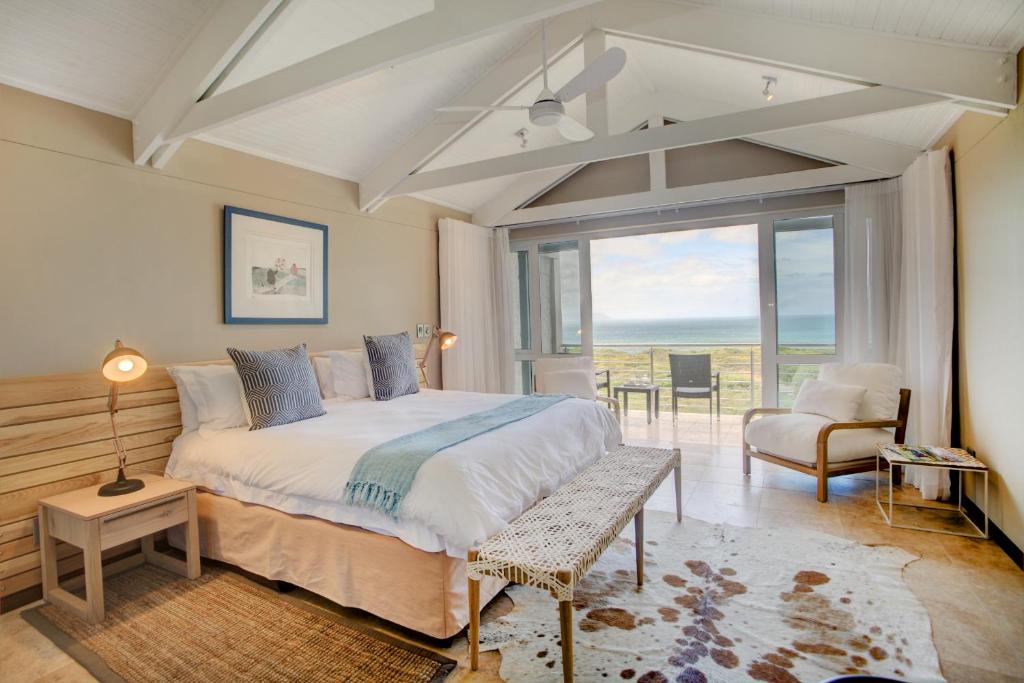 a bedroom with a bed and a view of the ocean at Abalone Guest Lodge in Hermanus