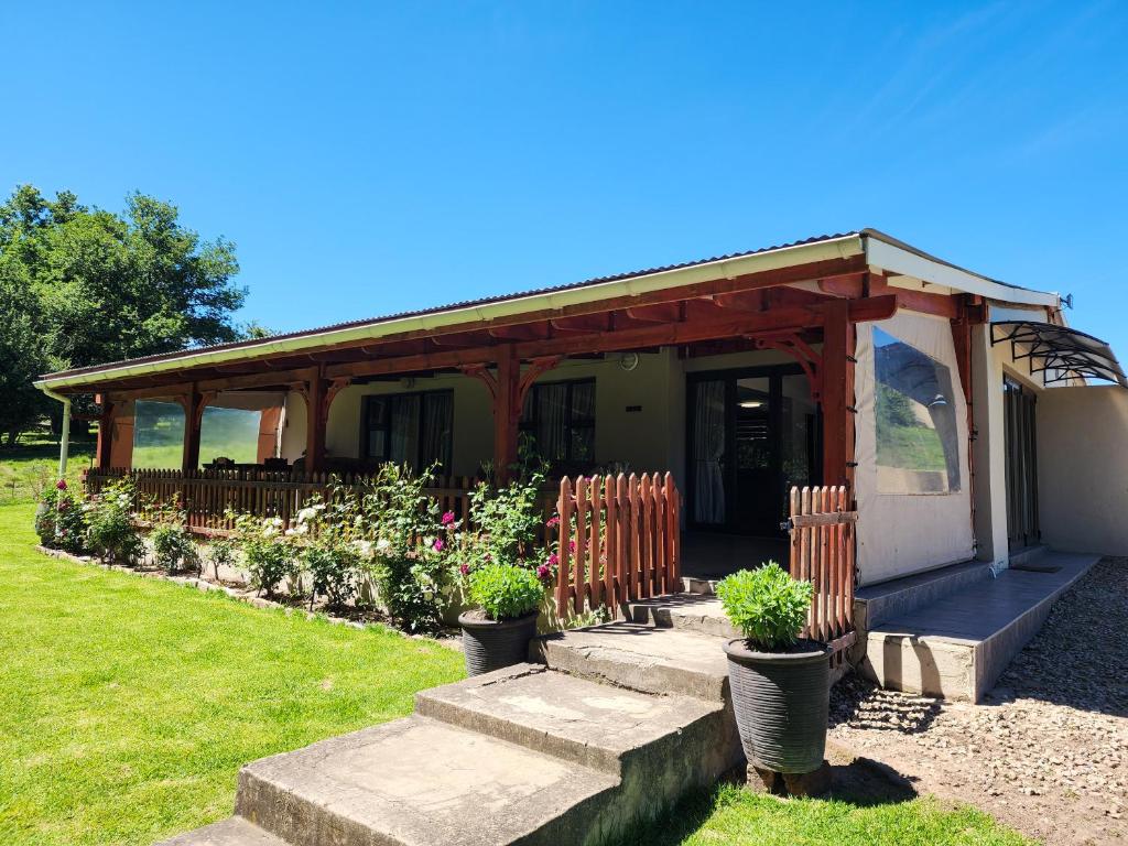 a small house with a porch and some plants at Hogsback Misty Oaks Cottage in Hogsback