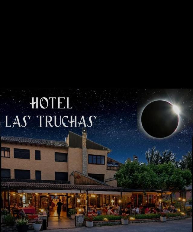 a view of a hotel with a moon in the sky at Hotel Las Truchas in Nuévalos