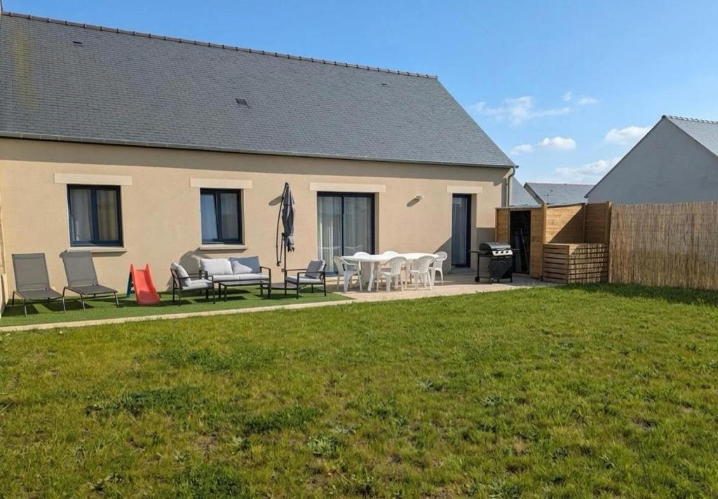 a house with chairs and tables and a grill at La Maison Menhiria in Dol-de-Bretagne