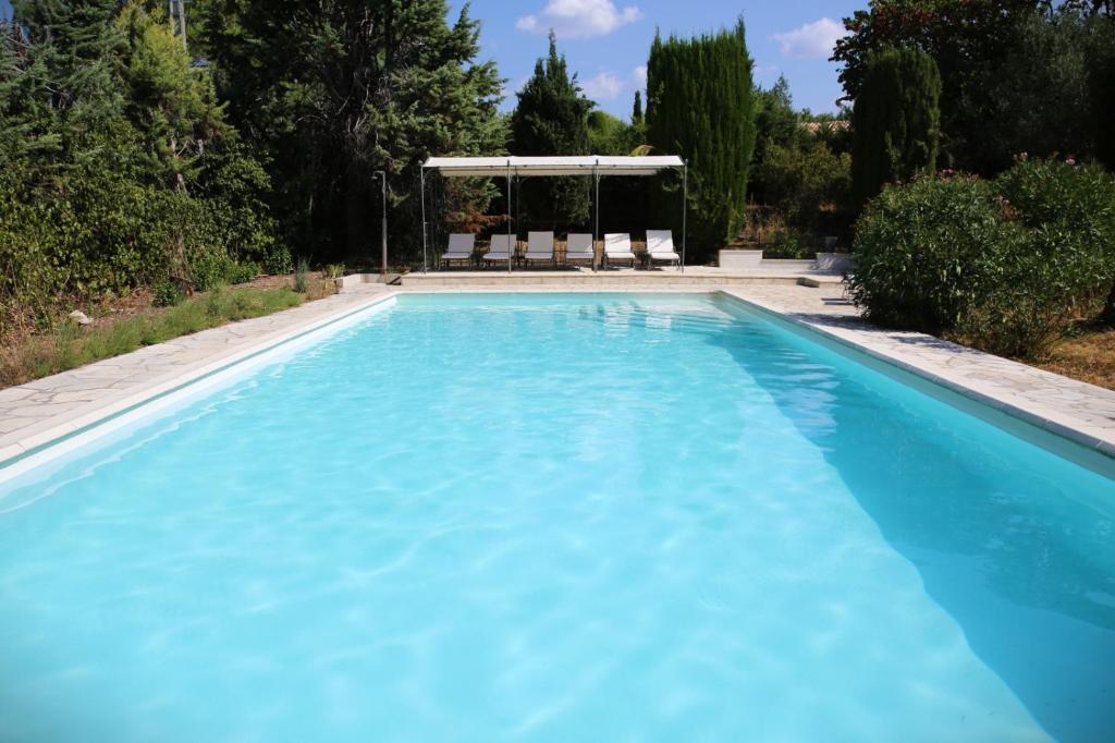 a swimming pool with blue water at La chambre du Mazet in Fayence