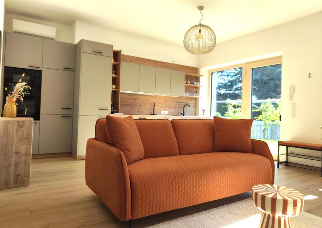 a living room with an orange couch in a kitchen at Rauchhof in Auer