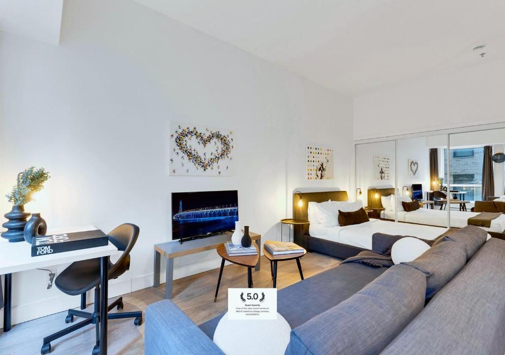 a living room with a couch and a bed at LiV MTL Downtown Montreal Spacious Suites in Montreal
