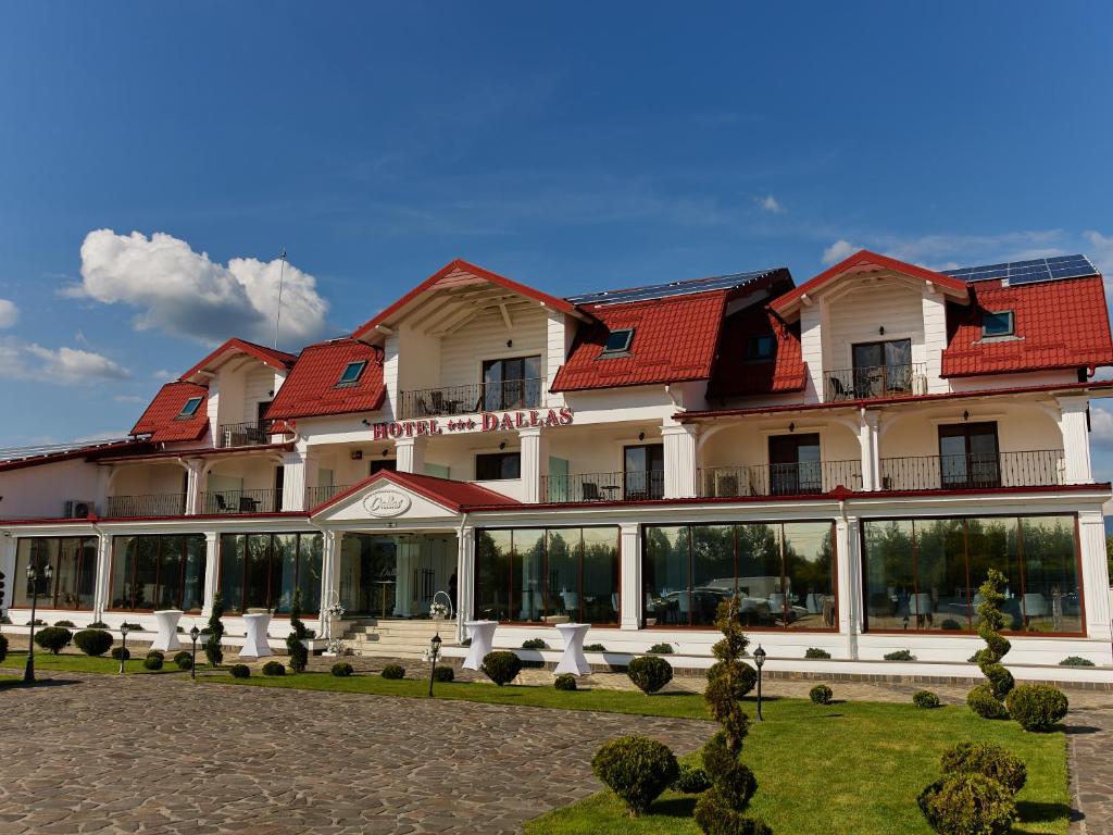 a hotel with a large building with red roof at Hotel Dallas in Negreşti-Oaş