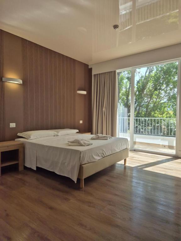 a bedroom with a large bed and a large window at Hsdominicus in Cirella