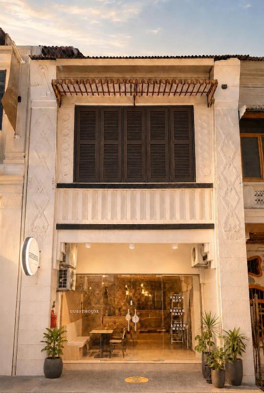 a store front of a building with a table and chairs at Commune Lane Guesthouse, George Town in George Town