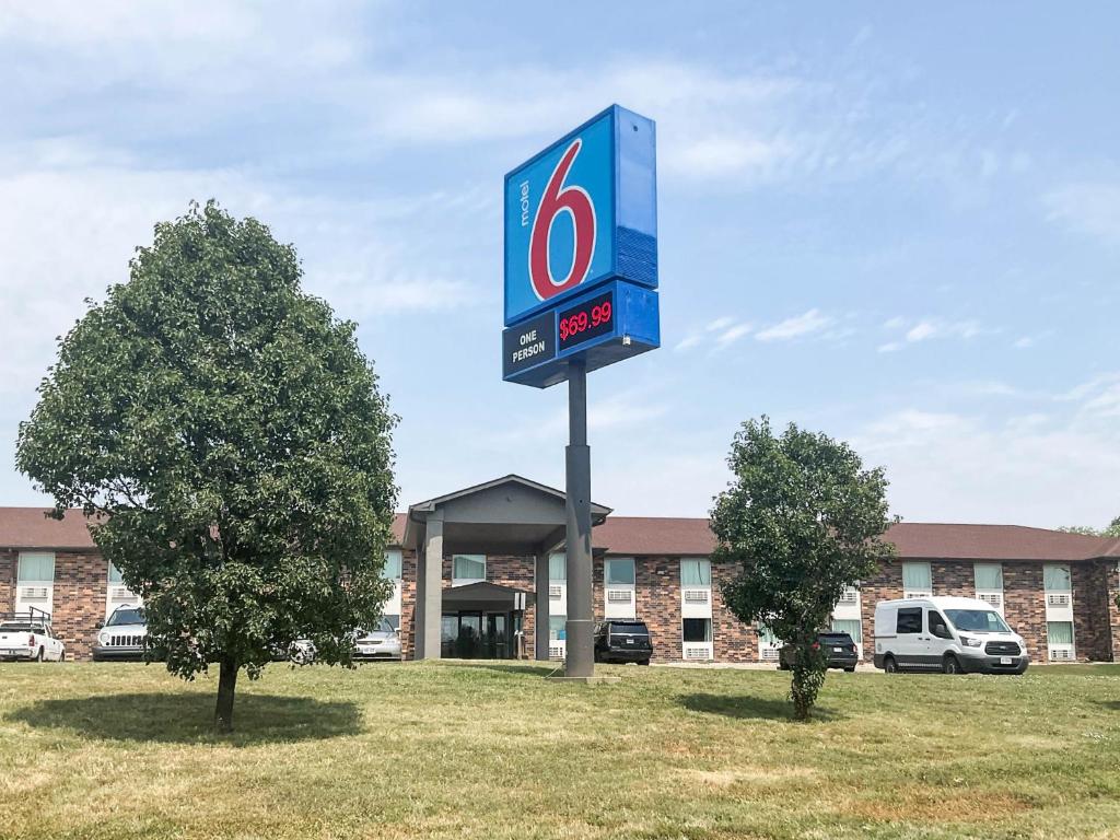 a sign for a gas station in front of a building at Motel 6 Omaha - Central in La Vista