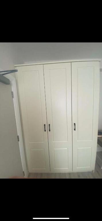 a pair of white cabinets in a kitchen at The Urban Haven in Limerick