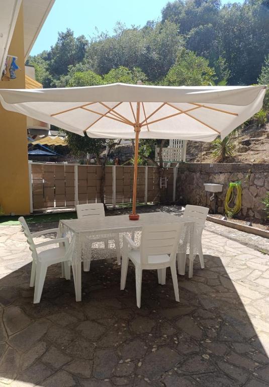 a white table and chairs under an umbrella at Casa Smeraldo in Cavo