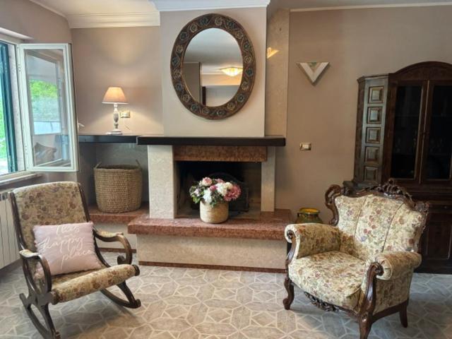 a living room with two chairs and a fireplace at A casa di Lea2 in Gioia dei Marsi