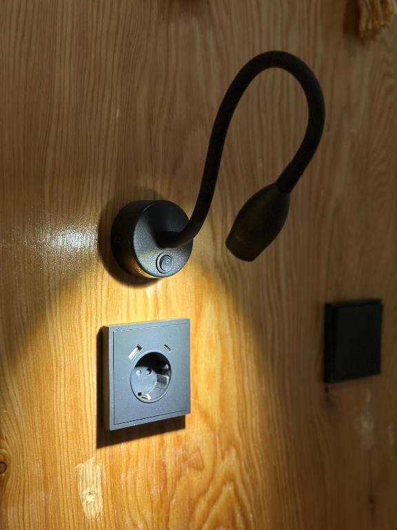 a pair of headphones plugged into a light on a wall at Teskey Hostel Karakol in Karakol