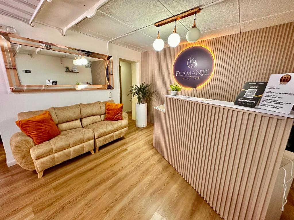 a living room with a couch and a counter at Hotel Flamante Bulevar in Bogotá