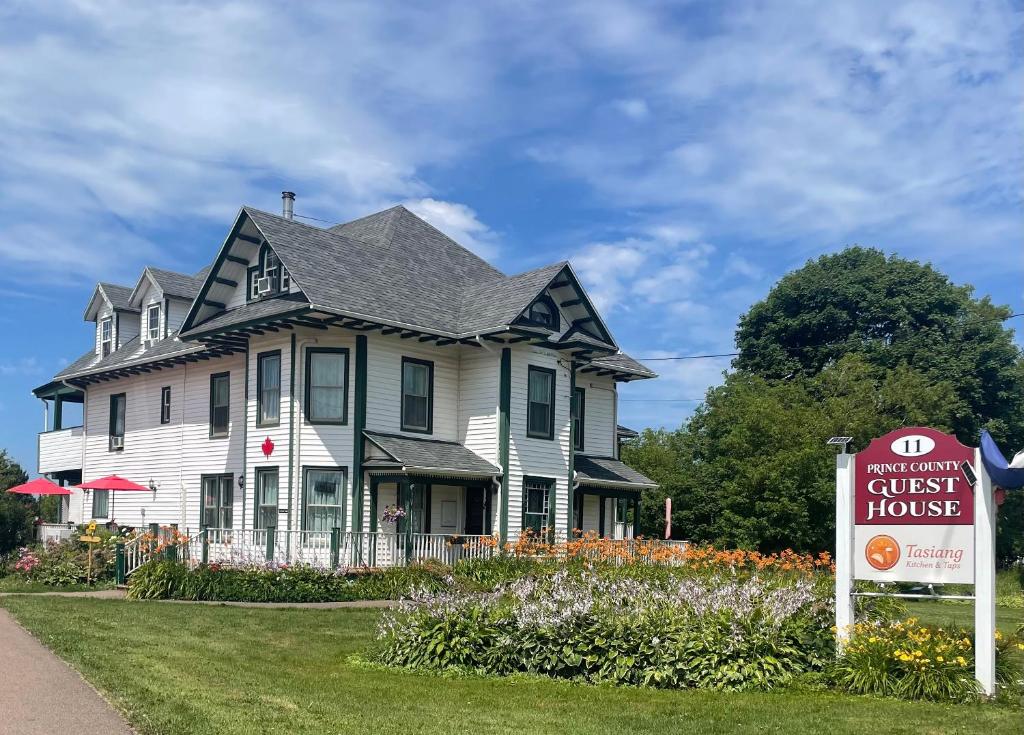 a house with a guest house sign in front of it at Prince County Guest House in Miscouche