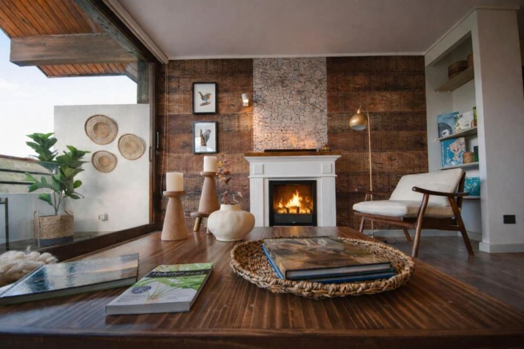 a living room with a fireplace and a table at Private Terrace with Wellness Studio & Fireplace in Puerto Varas