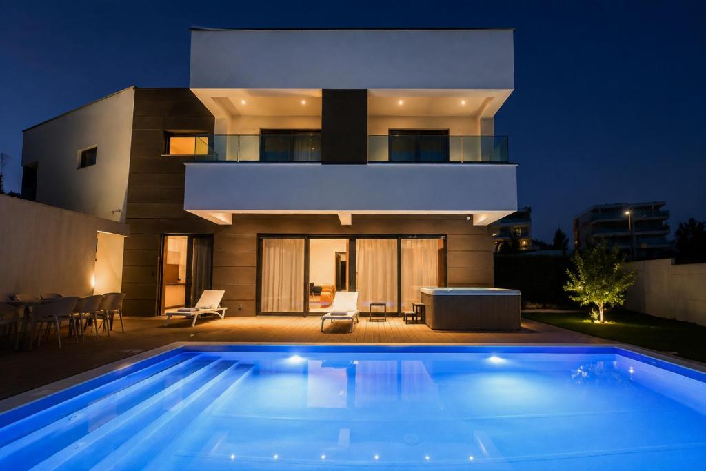a swimming pool in front of a house at night at Villa Estate in Novalja