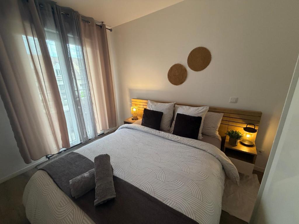 a bedroom with a large bed and a window at Appartement entier accès rapide Paris et parc dexpo in Sevran