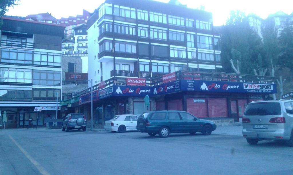 un grupo de coches estacionados frente a un edificio en Apartamento Plaza Pradollano 2, en Sierra Nevada