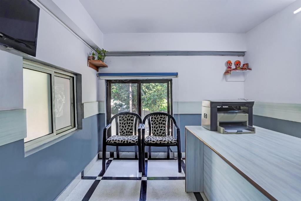 two chairs sitting at a counter in a kitchen at Hotel O DLF Phase 1 Metro Station Gurugram in Gurgaon