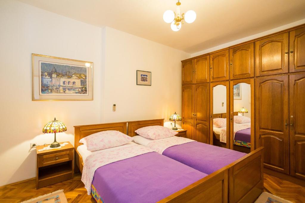 a bedroom with two beds and wooden cabinets at Apartment Dubrovnik Pile in Dubrovnik