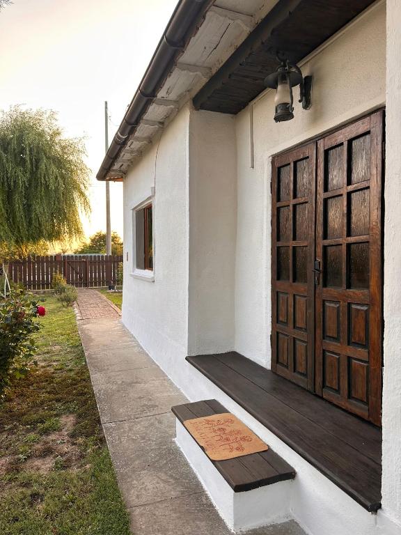 a house with a wooden door and a porch at Casa de Vacanta Sarinasuf in Sarinasuf