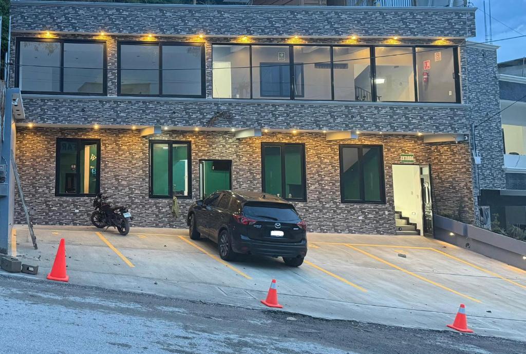 a car parked in a parking lot in front of a building at Hotel Gods Blessing in Nebaj