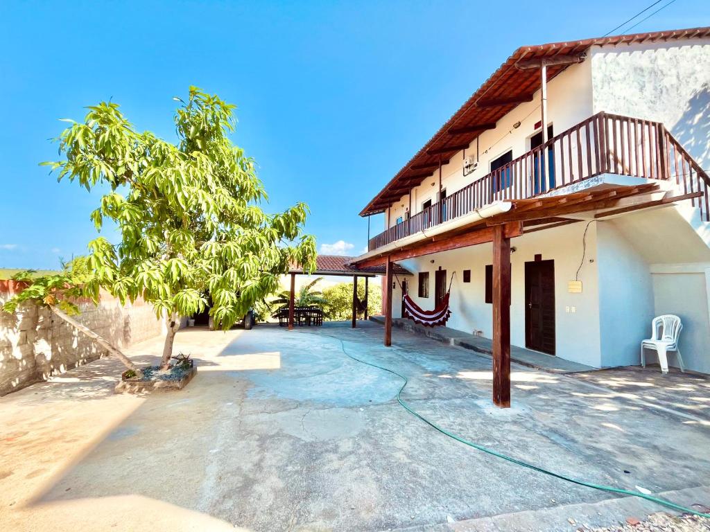 a patio of a house with a tree at Pousada Ondas do Vento in Tatajuba