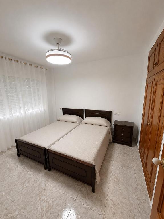 a bedroom with a large bed in a white room at Villa Nasra in Los Altos