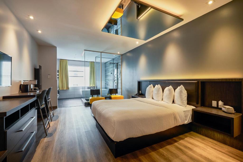 a hotel room with a bed and a kitchen at Hôtel Ô Laval in Laval
