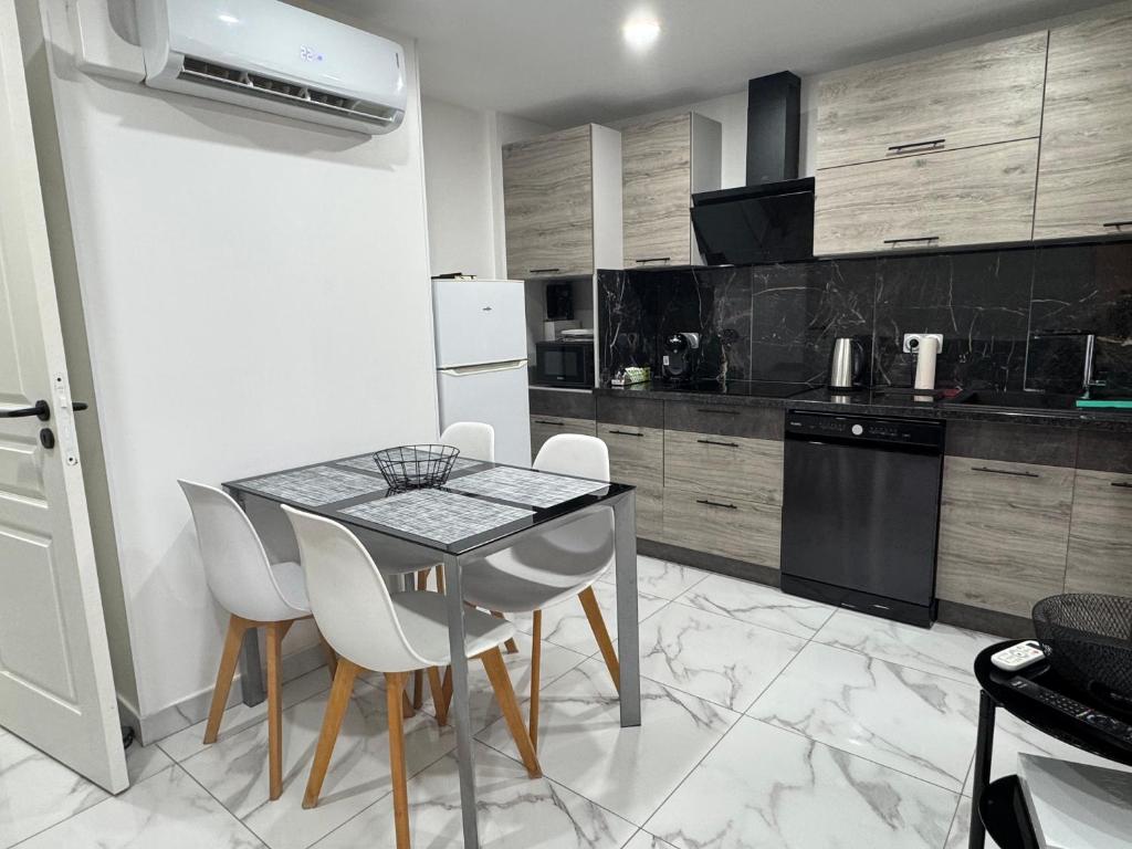 a kitchen with a table and chairs in a room at Appartement 300m de la mer in Valras-Plage