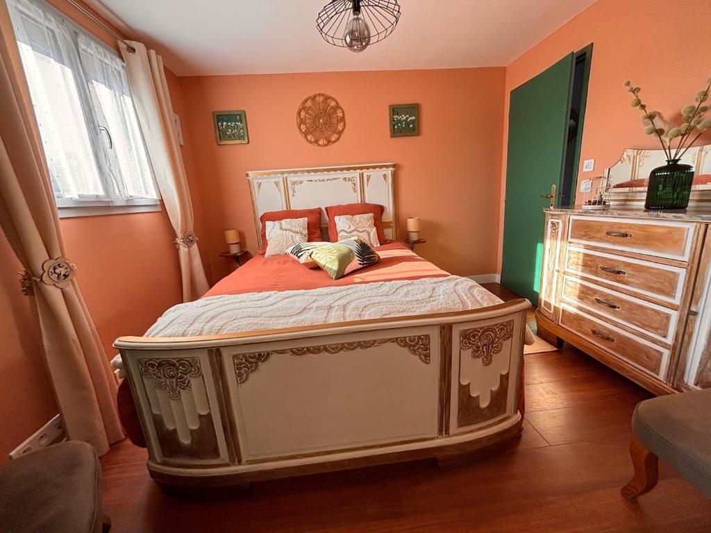 a bedroom with a bed and a dresser at Le Refuge des Vignes in Sainte-Colombe