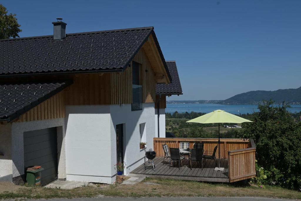 a house with a deck with a table and an umbrella at Haus Dorfinger in Aufham