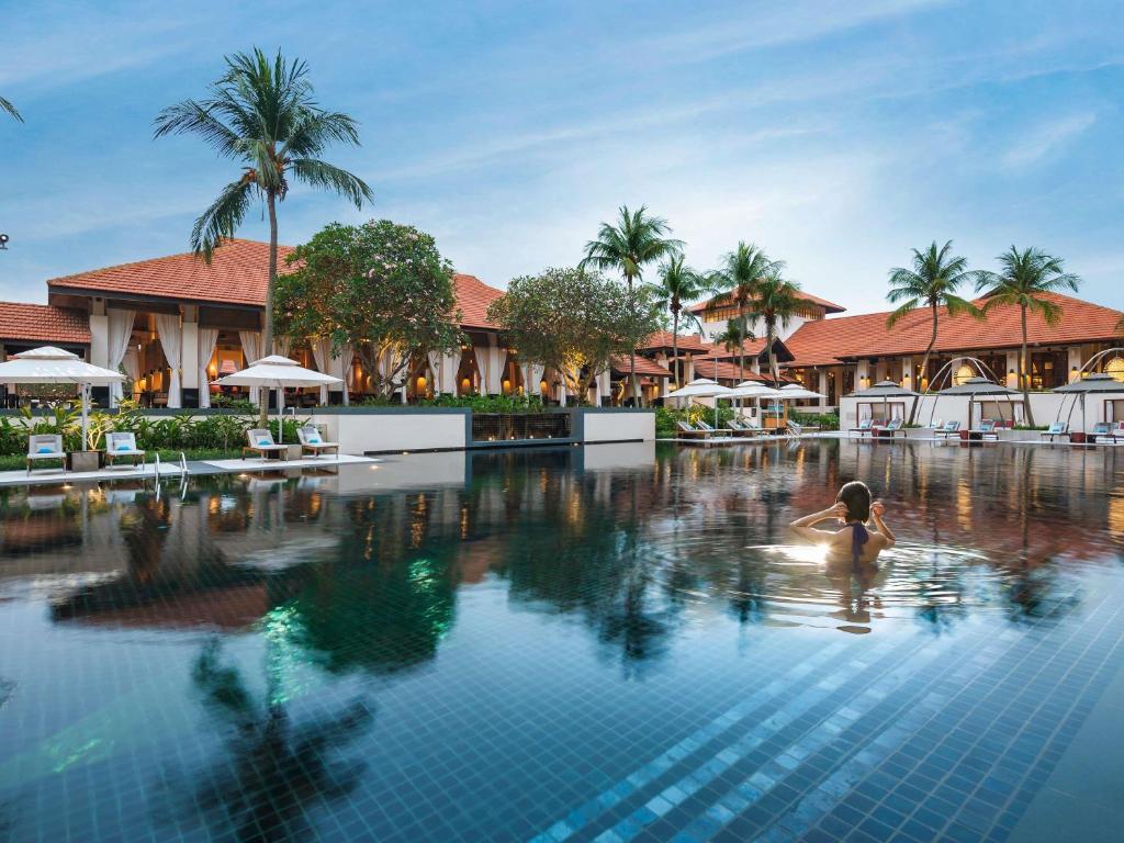 a person in a swimming pool at a resort at Sofitel Singapore Sentosa in Singapore