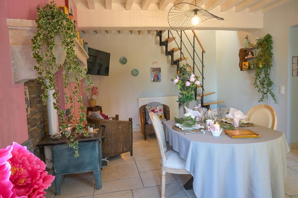 a dining room with a table with flowers on it at Rouges-Gorges 