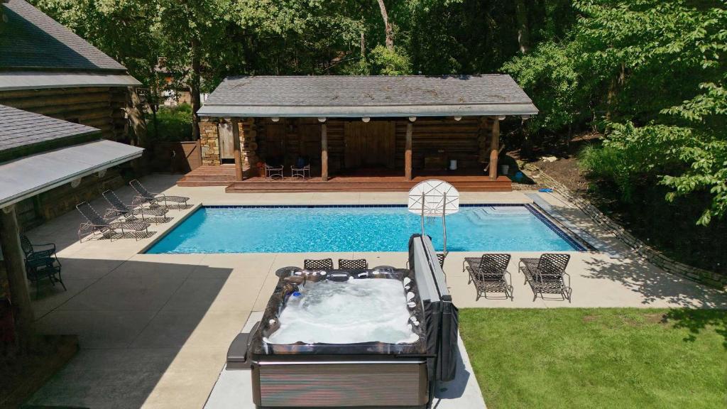 a swimming pool with a hot tub next to a cabin at Wilder Woods in Michiana