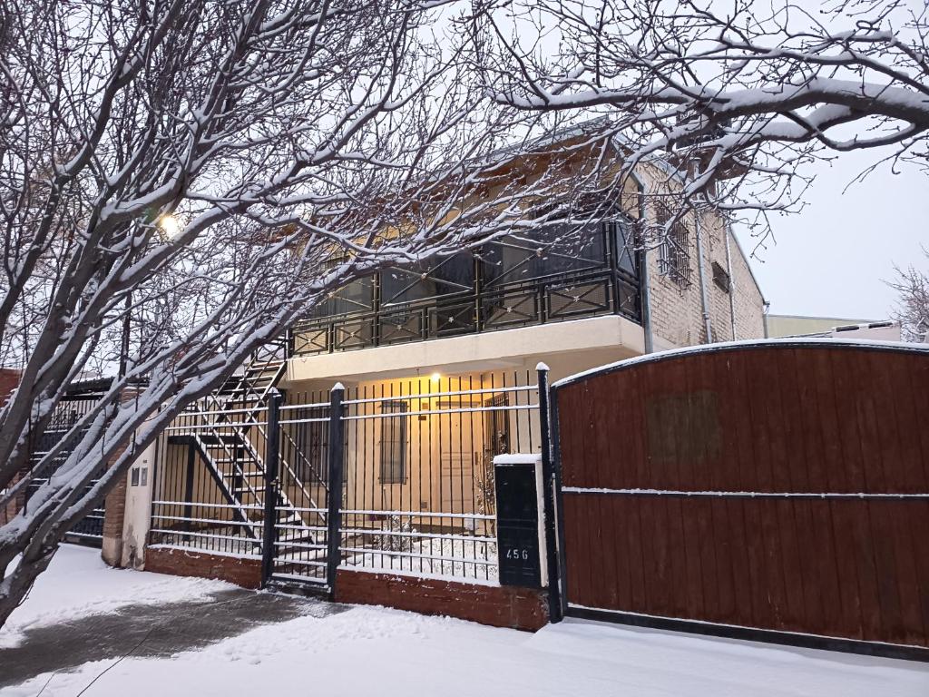 a building with a gate with snow on the ground at Departamento Asaï Malargüe in Malargüe