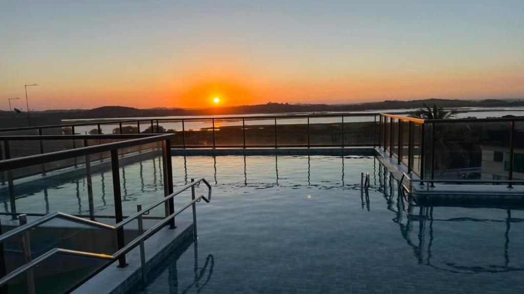 a pool of water with the sunset in the background at Porto Atlantis by You In | 80m from Porto de Galinhas Beach in Porto De Galinhas