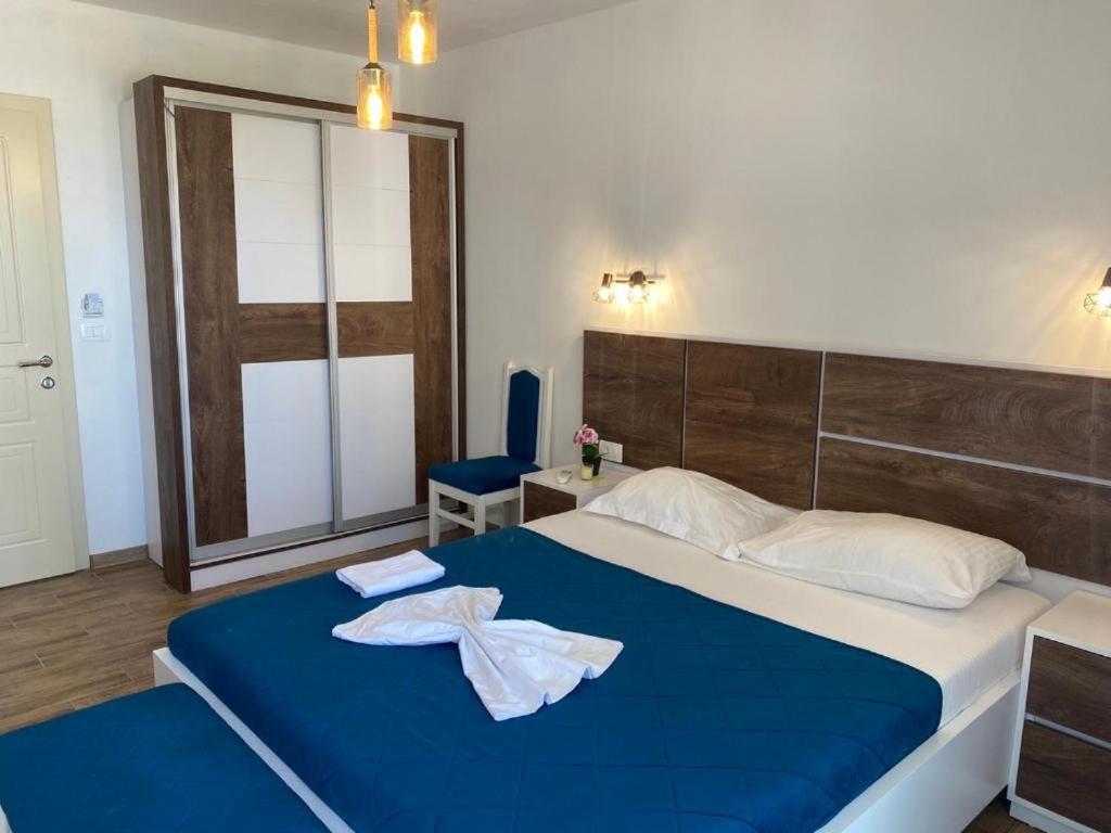 a bedroom with a blue bed with a robe on it at Casa Kollari in Ulcinj