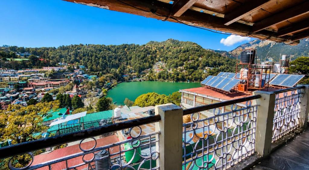 a view from the balcony of a building with a green lake at Naini Hill View Boho in Nainital