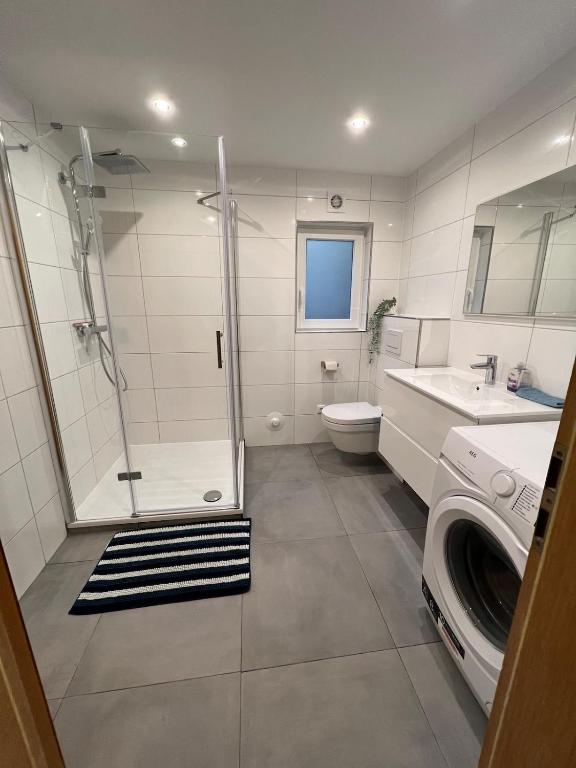 a bathroom with a shower and a washing machine at Ruhig gelegene Ferienwohnung in Waldbrunn